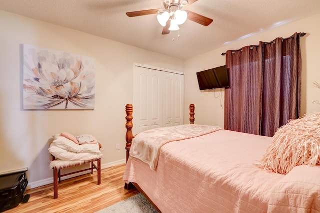 bedroom featuring ceiling fan, light wood-type flooring, a textured ceiling, and a closet