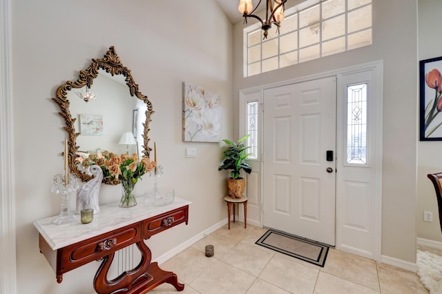 foyer with a towering ceiling, light tile patterned flooring, and a notable chandelier