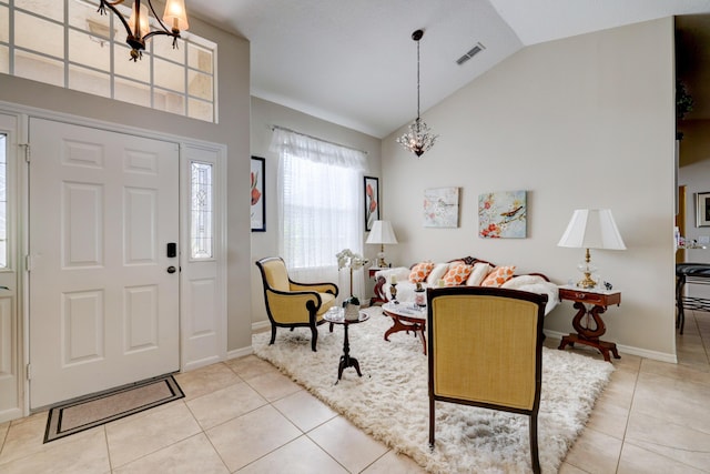 tiled foyer featuring a chandelier and lofted ceiling