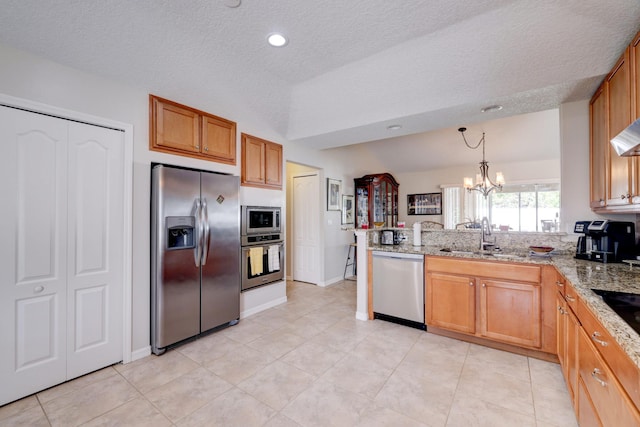 kitchen featuring kitchen peninsula, appliances with stainless steel finishes, a textured ceiling, sink, and a notable chandelier