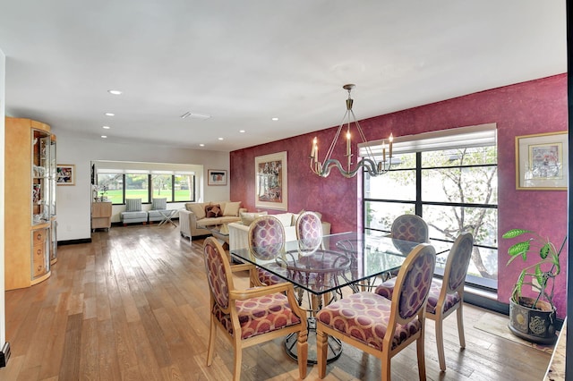 dining area featuring light hardwood / wood-style floors and an inviting chandelier