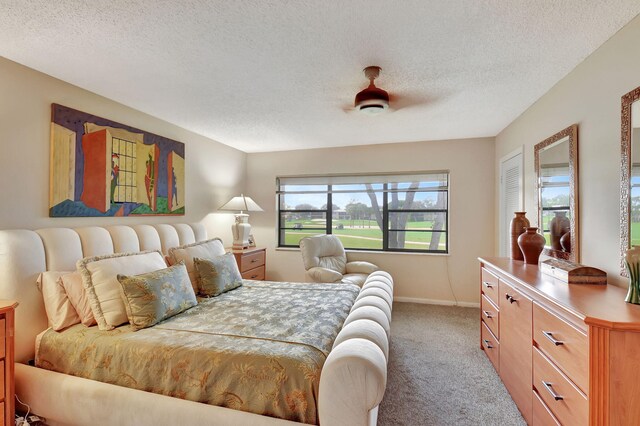 carpeted bedroom with ceiling fan and a textured ceiling