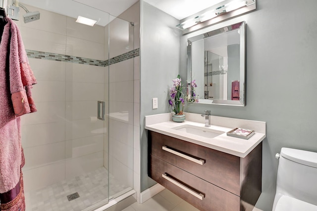 bathroom with walk in shower, tile patterned floors, vanity, and toilet