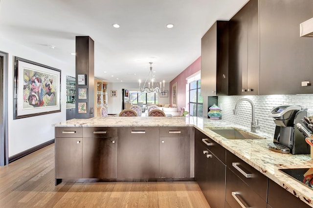 kitchen featuring light stone counters, light hardwood / wood-style flooring, and sink