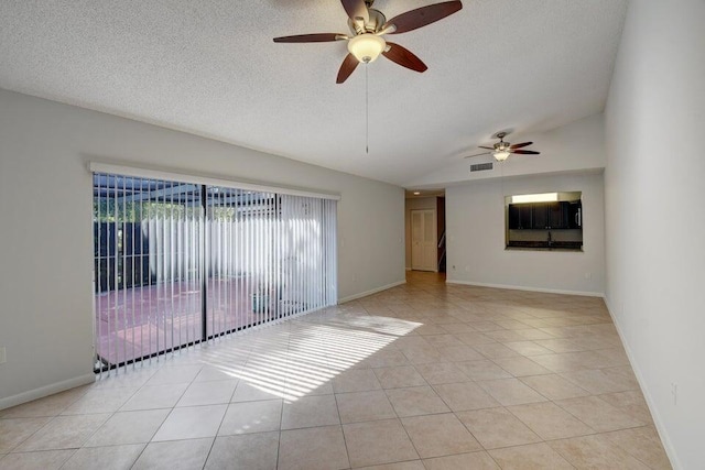 tiled spare room with a textured ceiling, ceiling fan, and vaulted ceiling