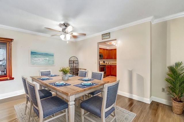 dining room with ceiling fan, light wood-type flooring, and ornamental molding