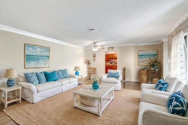 living room with ceiling fan, wood-type flooring, and ornamental molding