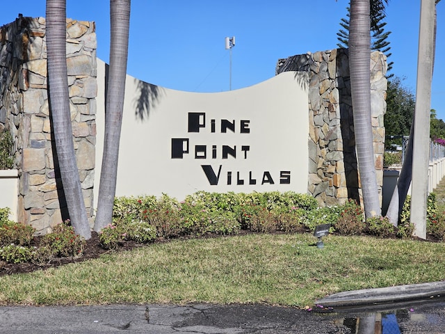 community / neighborhood sign featuring a lawn