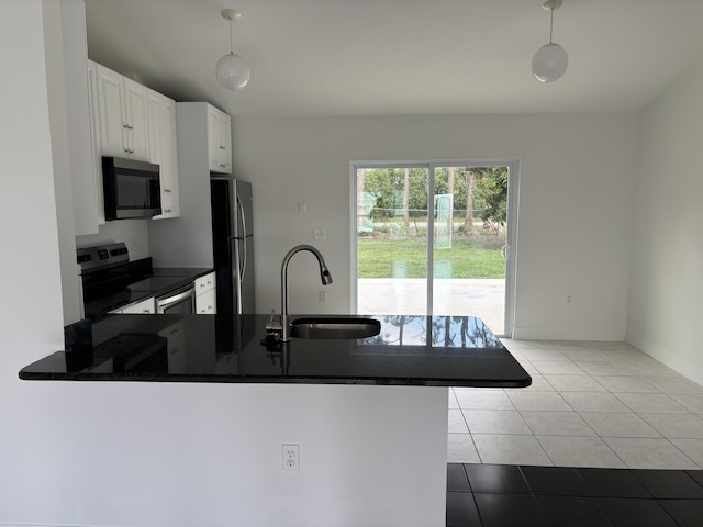 kitchen featuring a sink, white cabinetry, appliances with stainless steel finishes, tile patterned floors, and dark countertops