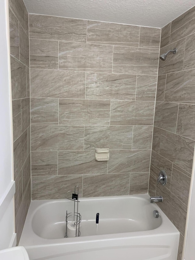 full bath with shower / tub combination and a textured ceiling