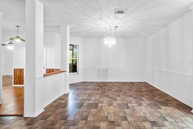 unfurnished room featuring a chandelier, a textured ceiling, and hardwood / wood-style flooring