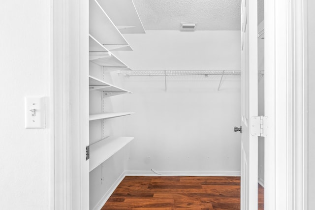 spacious closet featuring dark hardwood / wood-style flooring