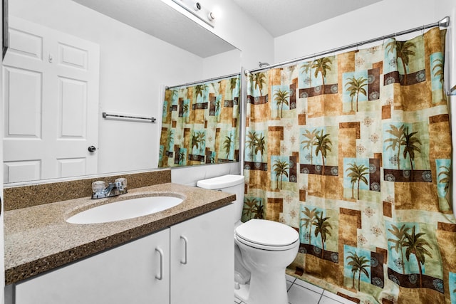 bathroom featuring toilet, a shower with curtain, vanity, and tile patterned floors