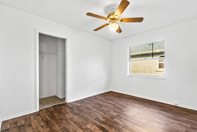 unfurnished bedroom with ceiling fan, dark hardwood / wood-style flooring, a textured ceiling, and a closet