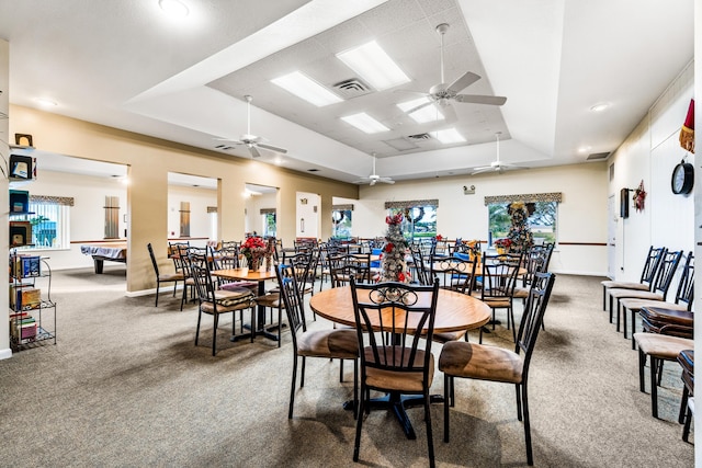 dining area featuring a tray ceiling, carpet flooring, visible vents, and baseboards