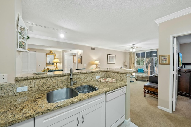 kitchen with white dishwasher, sink, a textured ceiling, light colored carpet, and white cabinetry