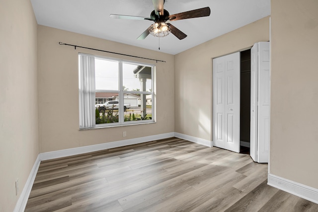 unfurnished bedroom with ceiling fan, light hardwood / wood-style floors, and a closet