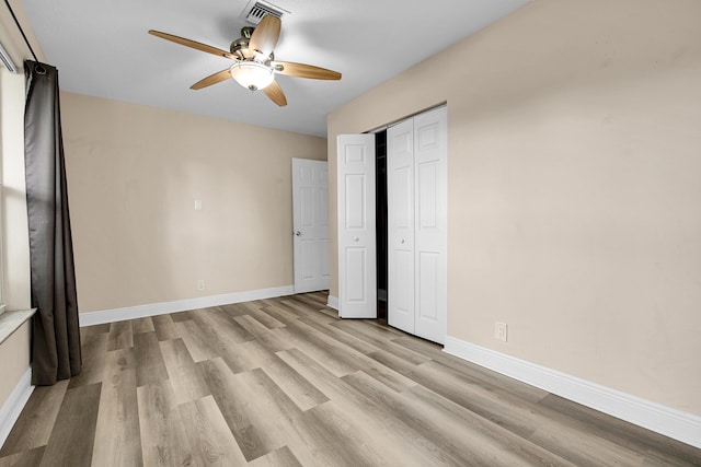 unfurnished bedroom with a closet, light hardwood / wood-style flooring, and ceiling fan