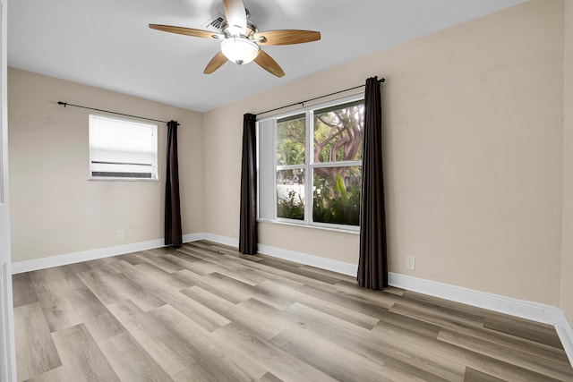 empty room with ceiling fan and light hardwood / wood-style flooring