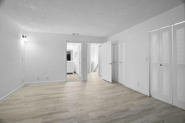 empty room featuring light hardwood / wood-style floors and a textured ceiling