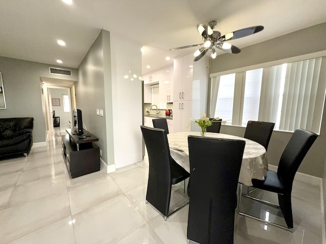 tiled dining area with ceiling fan and sink