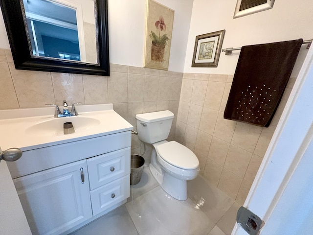 bathroom with vanity, tile walls, and toilet