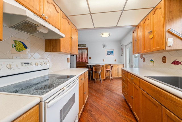 kitchen with dark wood-type flooring, backsplash, and white range with electric cooktop