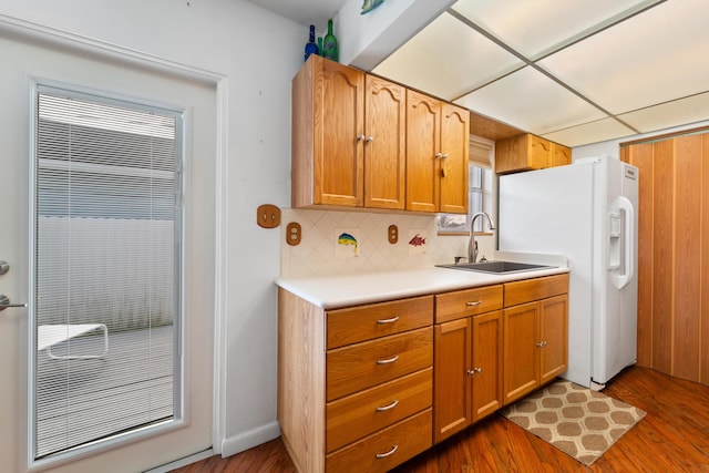 kitchen featuring sink, a paneled ceiling, backsplash, dark hardwood / wood-style floors, and white fridge with ice dispenser