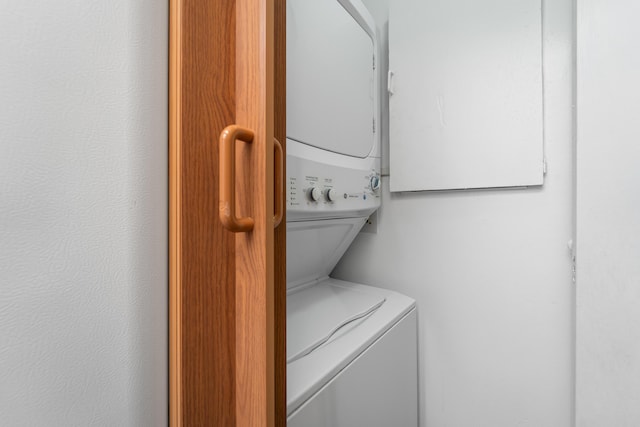 washroom featuring stacked washer / drying machine