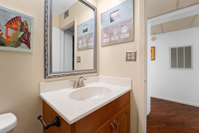 bathroom featuring vanity, hardwood / wood-style floors, and toilet