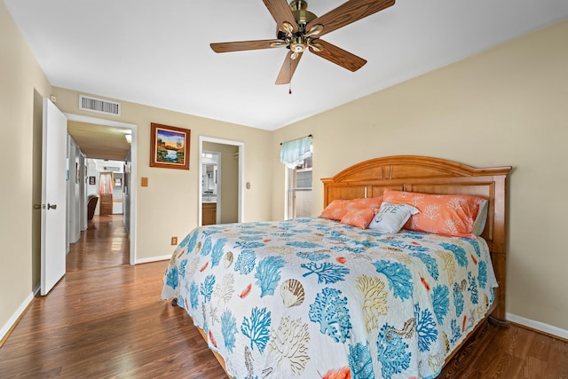 bedroom with ceiling fan, ensuite bathroom, and dark hardwood / wood-style flooring