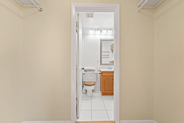 walk in closet with light tile patterned flooring and sink