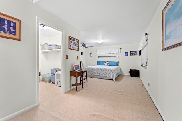 bedroom with a closet, a spacious closet, and light carpet