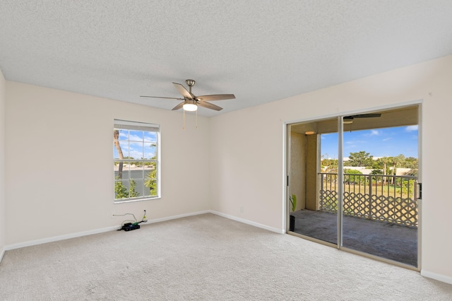 carpeted spare room with a textured ceiling and ceiling fan