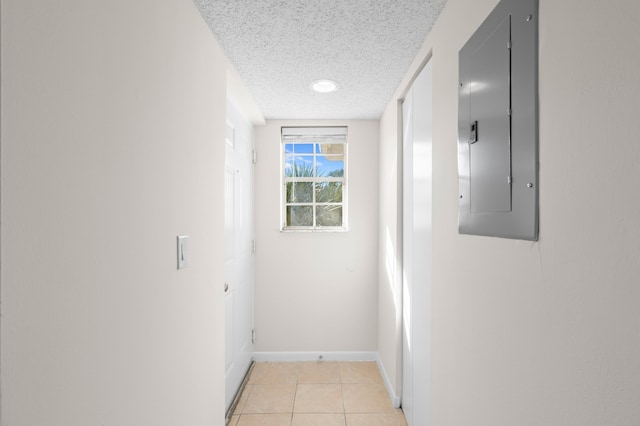 hallway with electric panel, light tile patterned floors, and a textured ceiling