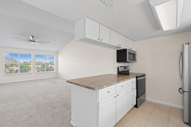 kitchen featuring white cabinets, ceiling fan, a textured ceiling, appliances with stainless steel finishes, and light colored carpet