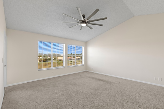 empty room with carpet, ceiling fan, a textured ceiling, and vaulted ceiling