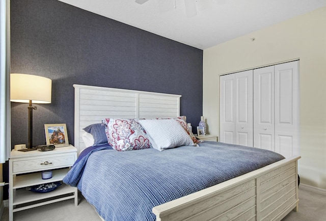 bedroom featuring ceiling fan, a closet, and light colored carpet