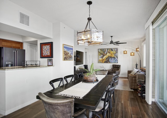 dining area with dark hardwood / wood-style flooring and ceiling fan with notable chandelier