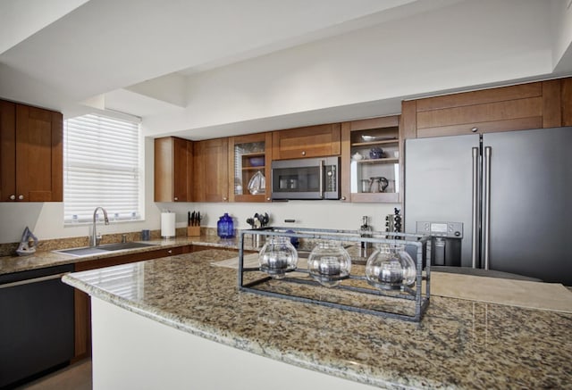 kitchen featuring appliances with stainless steel finishes, light stone counters, and sink