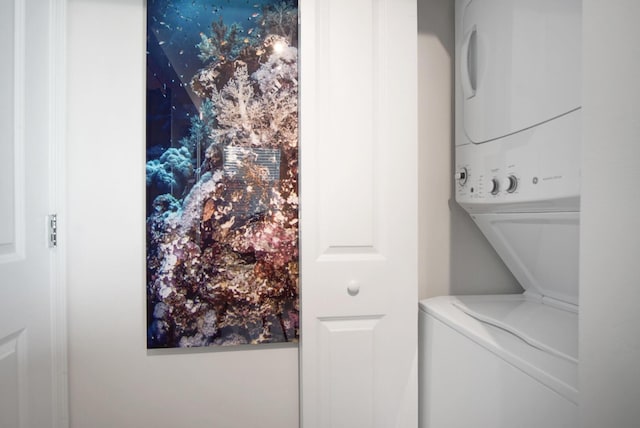 clothes washing area featuring stacked washer and clothes dryer