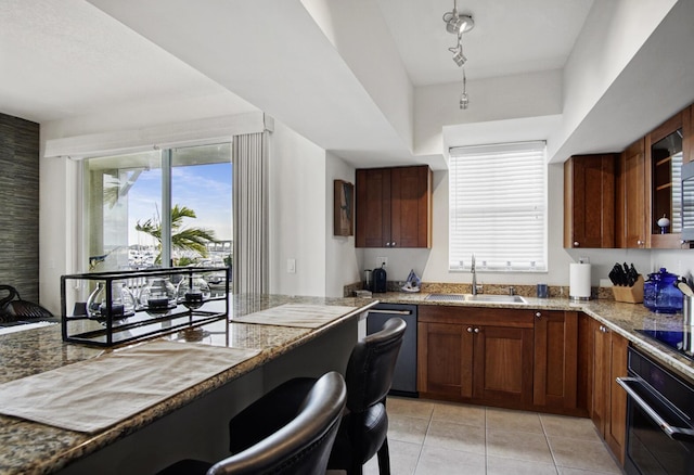 kitchen with light stone countertops, sink, light tile patterned flooring, and black appliances