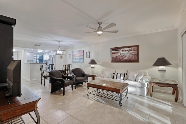 living room with light tile patterned floors, ceiling fan with notable chandelier, and ornamental molding