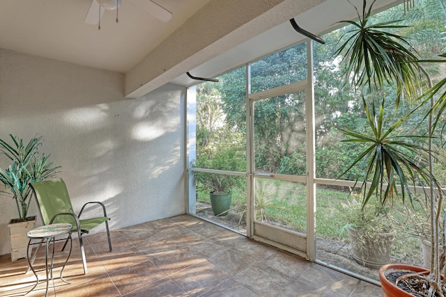 unfurnished sunroom with ceiling fan