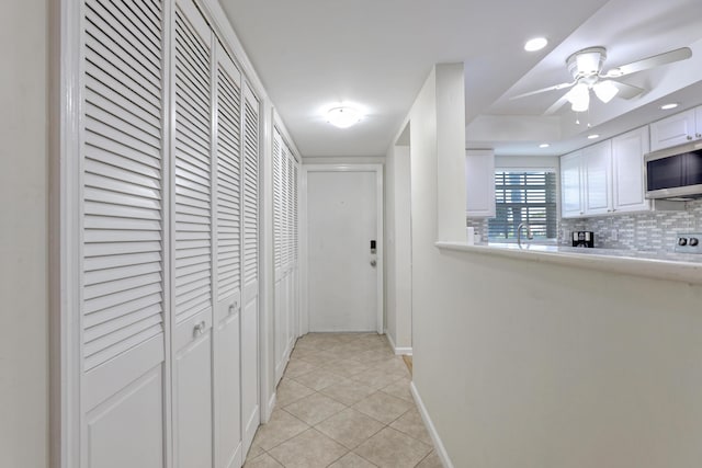 corridor with light tile patterned floors and sink