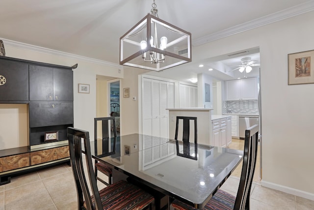 tiled dining space featuring ceiling fan with notable chandelier and ornamental molding