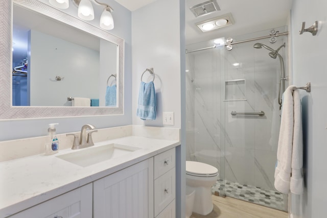 bathroom with wood-type flooring, vanity, toilet, and an enclosed shower