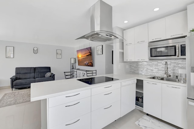 kitchen with black electric stovetop, white cabinets, tasteful backsplash, island range hood, and kitchen peninsula