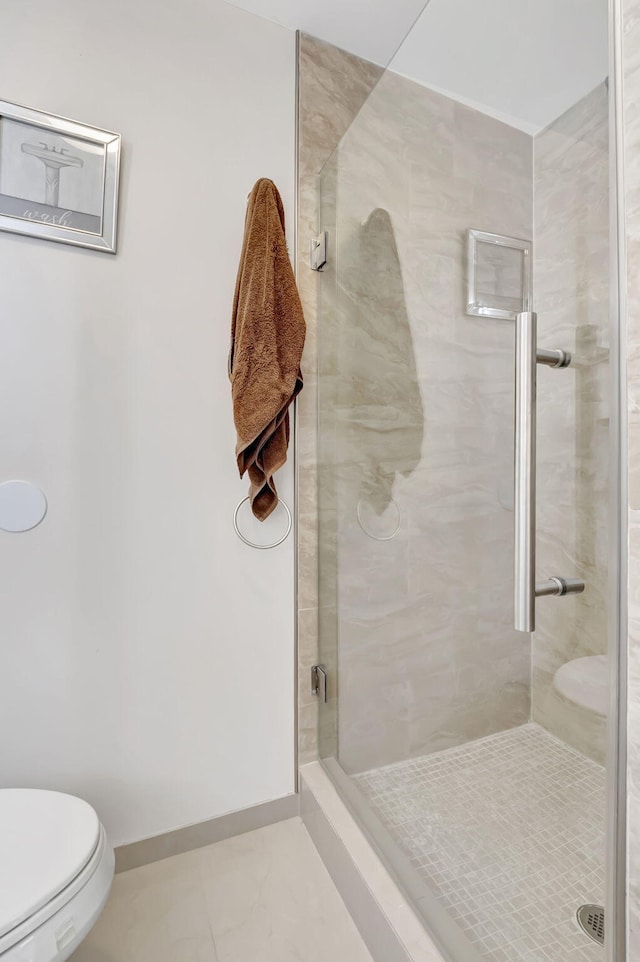 bathroom featuring toilet and a shower with door