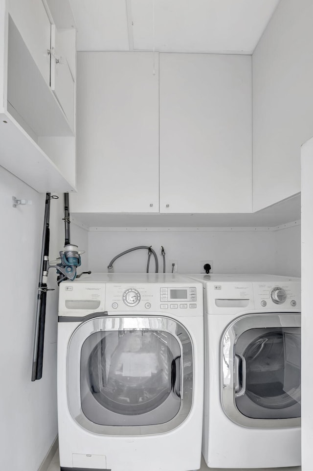 laundry room featuring cabinets and washing machine and dryer